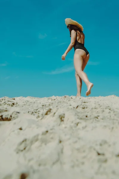 Mujer en playa de arena en traje de baño negro cielo azul sobre fondo — Foto de Stock