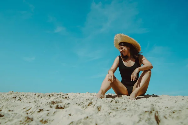 Mulher na praia de areia em preto maiô céu azul no fundo — Fotografia de Stock
