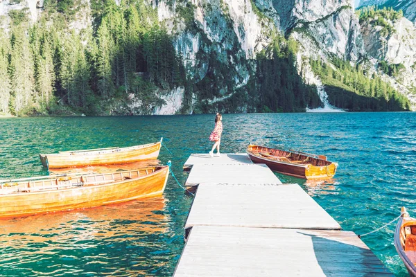 Mulher no cais com barcos de madeira no lago da montanha — Fotografia de Stock