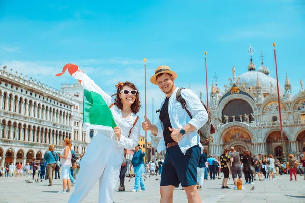 Усміхнена пара тримає італійський прапор Венеція центральна площа Сан-Марко — стокове фото