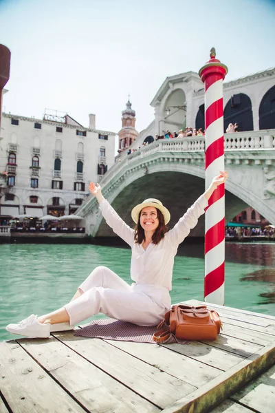 Жінка сидить біля мосту Ріальто у Венеції Італія дивиться на Гранд-канал з гондолами — стокове фото