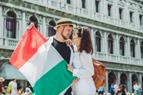 Поцілунки пара тримає італійський прапор Венеція центральна площа Сан-Марко — стокове фото