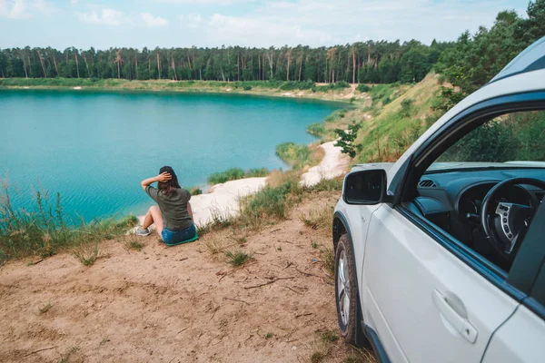 Žena sedící na kraji, který se těší pohledu na jezero — Stock fotografie