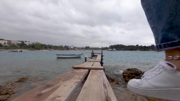 妇女走在木制钓鱼码头看暴风雨的海洋阴天 — 图库视频影像