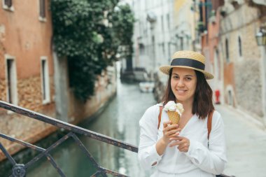 şehir caddesinde dondurma ile gülümseyen kadın