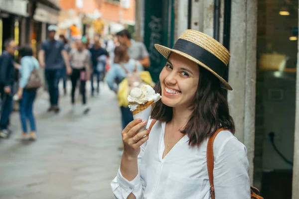 Улыбающаяся женщина с мороженым на городской улице — стоковое фото