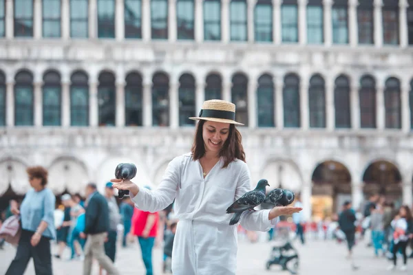 Woman in white clothes with straw hat having fun with pigeons at venice city square — Stock Photo, Image