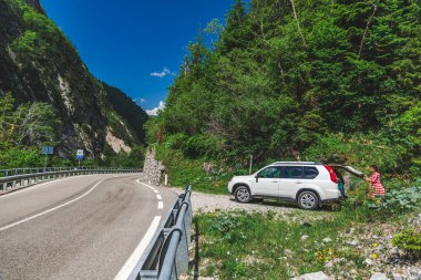 dağlarda yol kenarında beyaz SUV kadın yakın gövde