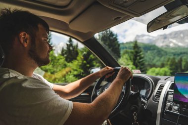 dağlara bakan araba kullanan adam