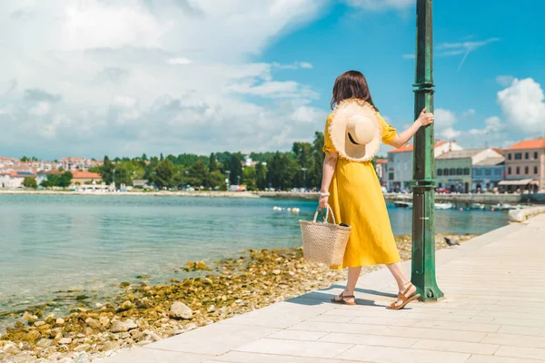 Frau läuft an einem Sommertag in gelber Kleidung am Kai entlang — Stockfoto