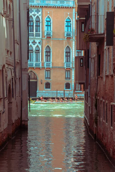 Az épület közötti csatornán való evezős csónakcsapat nézete — Stock Fotó