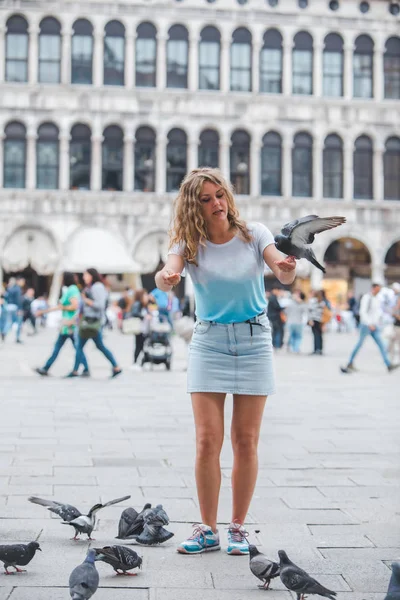 Frau amüsiert sich mit Tauben auf venezianischem Stadtplatz — Stockfoto