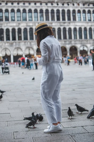 Woman in white clothes with straw hat having fun with pigeons at venice city square — Stock Photo, Image