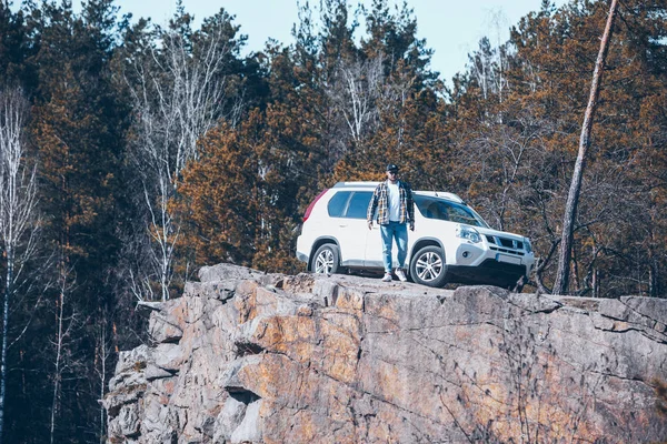 Jovem caminhando perto de carro branco suv na floresta — Fotografia de Stock