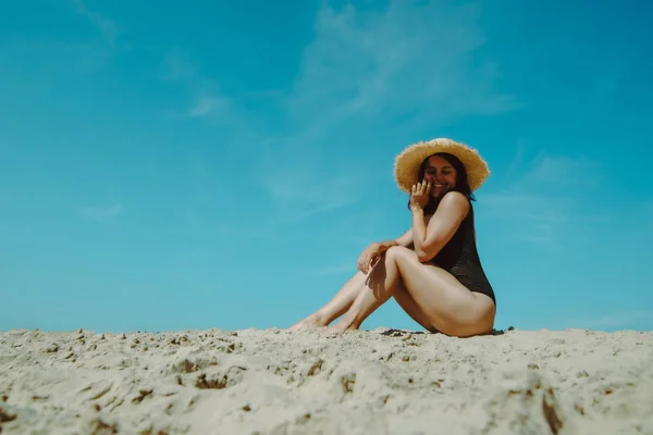 Arka planda siyah mayo mavi gökyüzü kum plajda kadın — Stok fotoğraf
