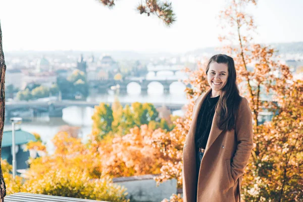 Giovane donna adulta in cappotto. bella praga su sfondo — Foto Stock