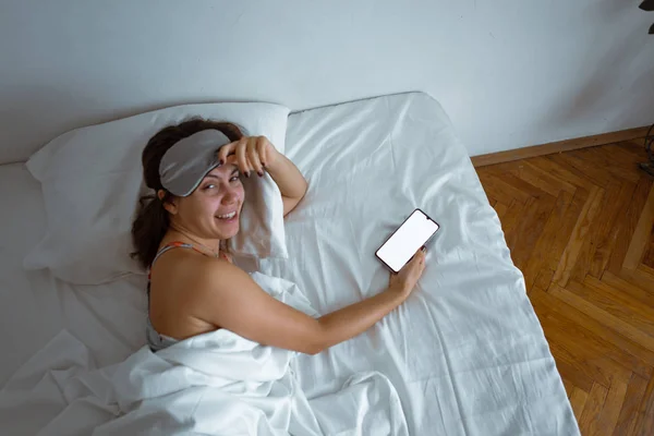 Жінка спить у сні маска смартфон поруч з нею — стокове фото