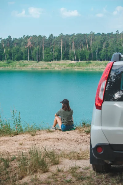 Žena sedící na kraji, který se těší pohledu na jezero — Stock fotografie