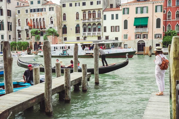 Venice, Italy - May 25, 2019: woman walking by wooden pier looking at grand canal at venice — Stock Photo, Image