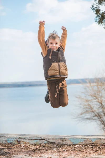 Pequeño lindo caucásico niño saltar al aire libre —  Fotos de Stock