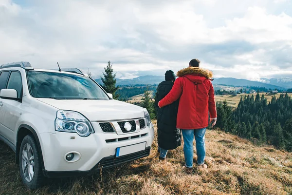 Dvojice drží a dívala se na nádherný výhled na hory. cestování autem silniční výlet — Stock fotografie