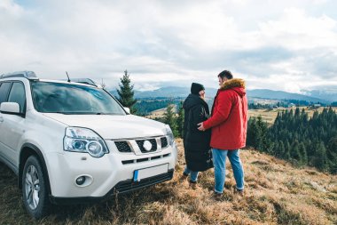 çift tutarak ve güzel dağlar görünümüne bakıyor. araba seyahat yol gezisi