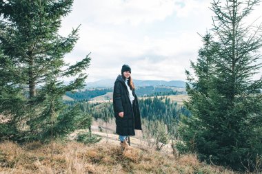 güzel dağlar görünümü ile uçurumda duran genç güzel kadın