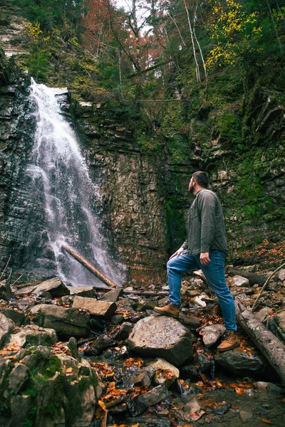 Man Hiking concept kijkend naar waterval in DIP forest — Stockfoto