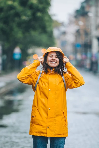 Fiatal szép mosolygó nő portré esőkabát kapucnival — Stock Fotó