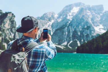 adam dağlarda göl onun telefonu fotoğraf çekmek