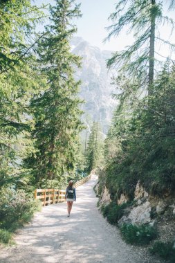 sırt çantası ile mutlu kadın arka planda milli park dağlarda iz ile yürüyüş