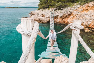 Asma köprü tarafından yürüyen adam