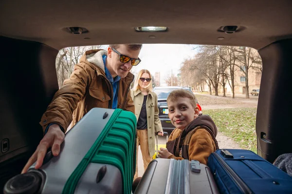 자동차 트렁크에 가방을 넣어 아이와 가족 — 스톡 사진