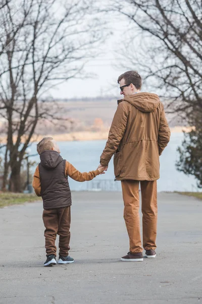 Πατέρας με τον γιο περπάτημα από το πάρκο κρατώντας τα χέρια — Φωτογραφία Αρχείου