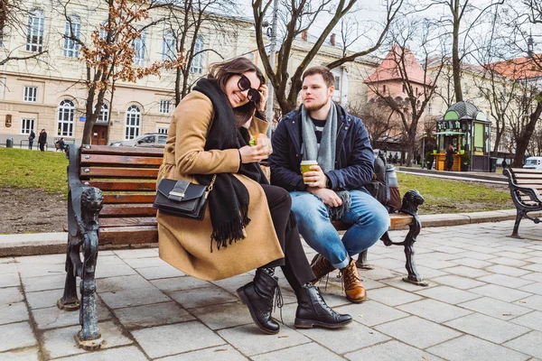 Young adult couple eating fast food on bench of city park — Stock Photo, Image