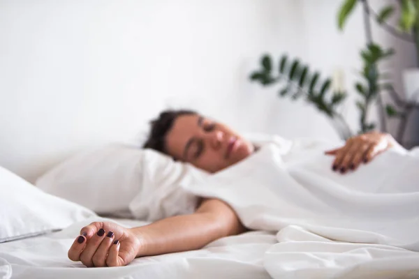 Woman sleeping in bed hand close up selective focus — Stock Photo, Image