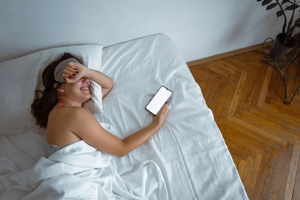 Woman sleeping in sleep mask smartphone near her — Stock Photo, Image