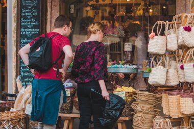 Hallstatt, Avusturya - 15 Haziran 2019: hediyelik eşya dükkanında mıknatıs ve diğer sevimli şeyleri seçen turistler