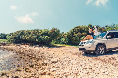 yaz plaj tatil konseptinde oto kaput üzerinde oturan kadın