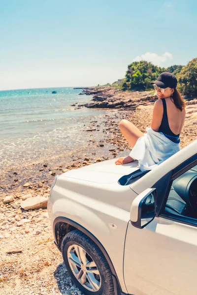 Frau liegt auf Motorhaube mit Blick auf Meer Sommerstrand — Stockfoto