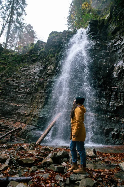 Femme près de cascade en forêt saison d'automne — Photo