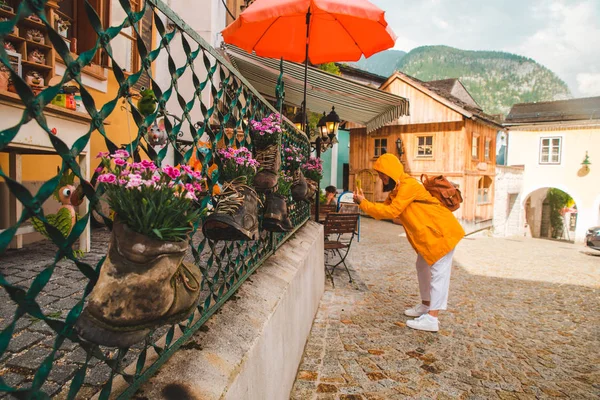 Donna scattare foto sul suo telefono a hallstatt strade della città — Foto Stock