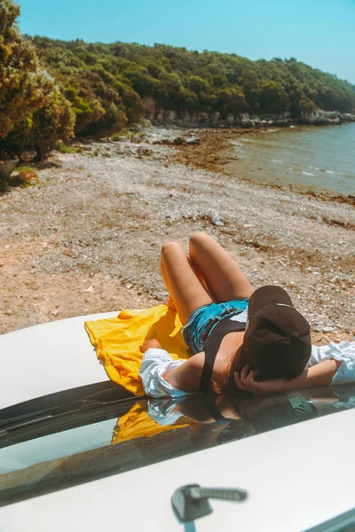 幸福的女人在海上夏天海滩坐在汽车罩 — 图库照片