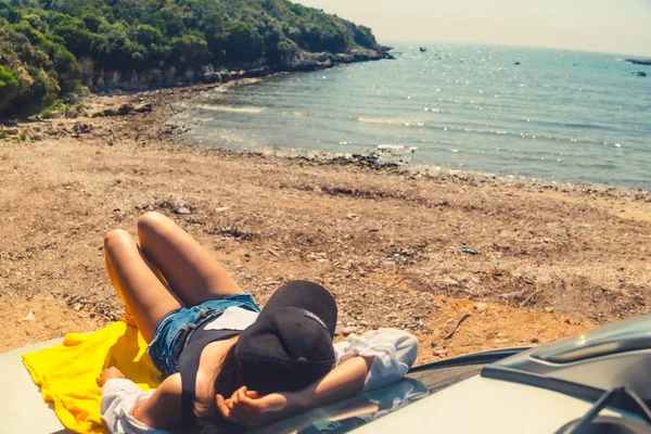 Gelukkige vrouw op zee zomer strand zittend op auto Hood — Stockfoto