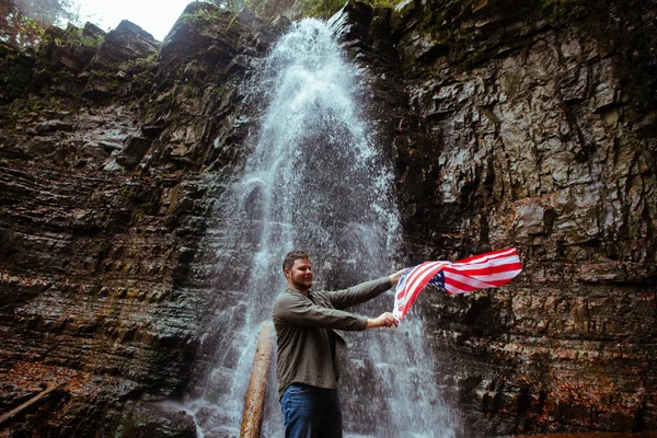 Man met USA vlag waterval op achtergrond — Stockfoto