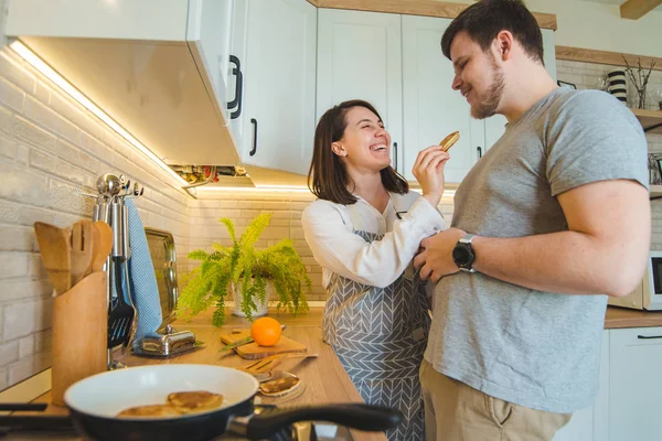Pareja en la cocina. mujer alimentando al hombre. cocinar juntos — Foto de Stock