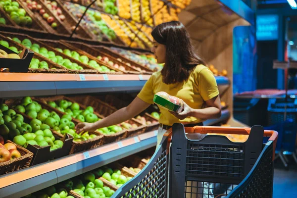 Jovem mulher adulta bonita fazer compras no supermercado — Fotografia de Stock