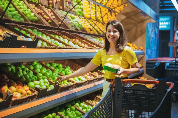 Junge hübsche erwachsene Frau beim Einkaufen im Lebensmittelgeschäft Apfel kaufen — Stockfoto