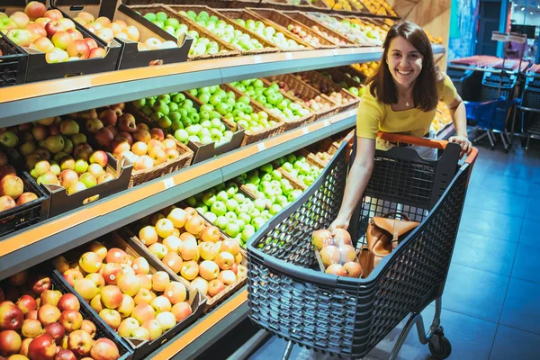 Jovem mulher adulta bonita fazer compras na mercearia comprar maçã — Fotografia de Stock