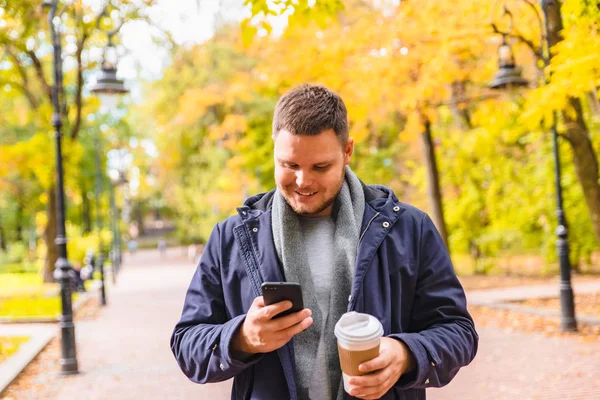 Man drinking coffee outdoors autumn season talking on the phone — Stock Photo, Image